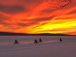 Snowmobilers riding into the sunset over Rangeley Lake - Click on the image above to access more Maine winter images.